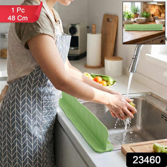 Green silicone splash guard with suction cups for sink protection.