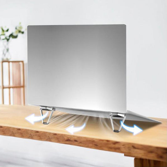 Compact foldable laptop stand made of metal, shown supporting a laptop on a desk.