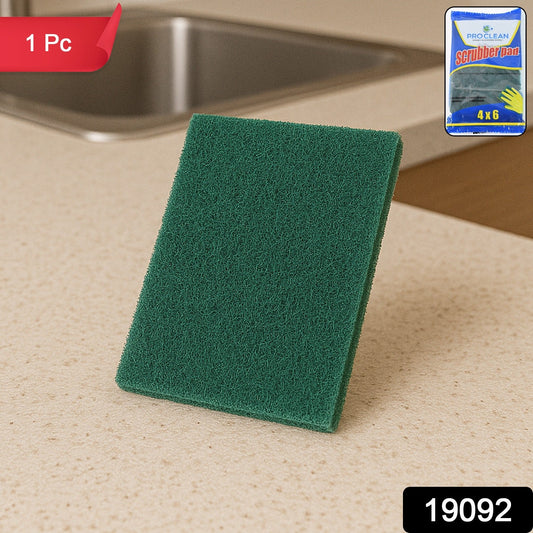 Green multipurpose kitchen scrubber pad removing grime on utensils